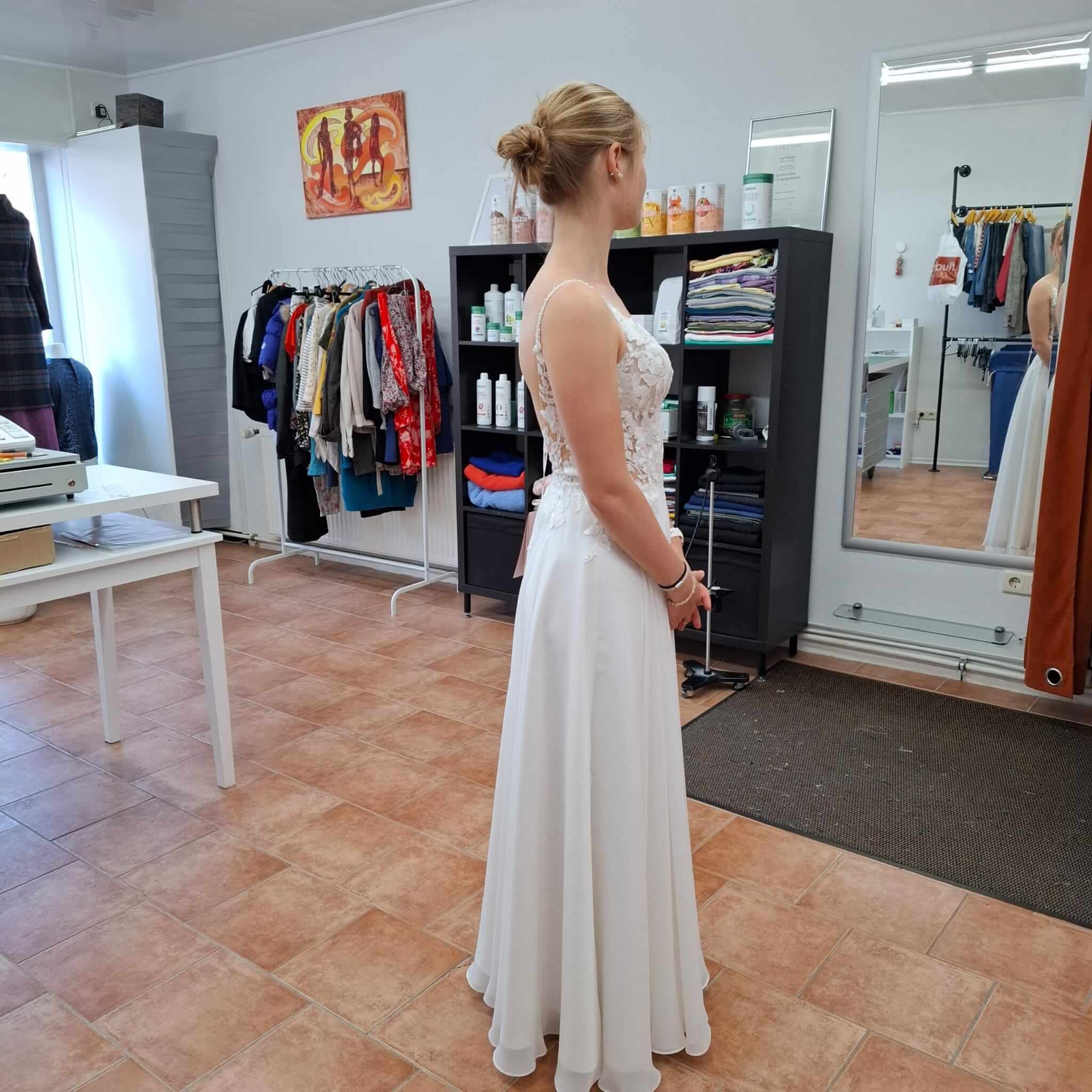 Anprobe eines karierten Sakkos vor dem Spiegel